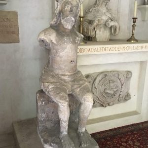 Sculpture en pierre figurant un Christ assis. L’ensemble présenté sur une colonne.