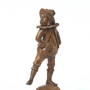Casse-noisettes en bois naturel sculpté figurant un personnage bedonnant vêtu d'une fraise et d'un chapeau à plumes.