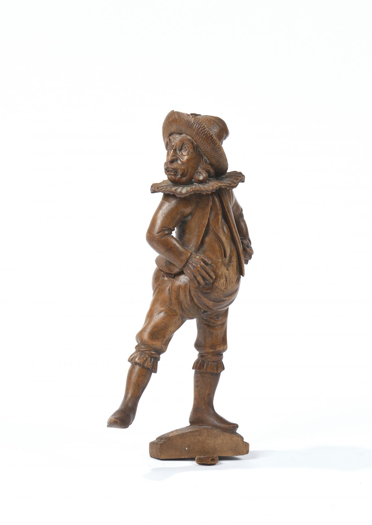 Casse-noisettes en bois naturel sculpté figurant un personnage bedonnant vêtu d'une fraise et d'un chapeau à plumes.