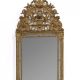 Important miroir parecloses en bois mouluré, sculpté et doré, le fronton à décor de panier fleuri flanqué de rinceaux feuillagés.