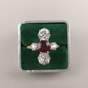 Bague en or jaune et gris 18K centrée d'un rubis épaulé de 4 diamants de taille ancienne les deux plus importants d'environ 0,75 carat