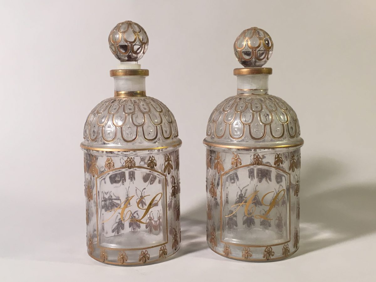GUERLAIN. Paire de flacons de parfum en verre moulé rehaussé d'or, à décor d'abeilles, monogrammés A. L.