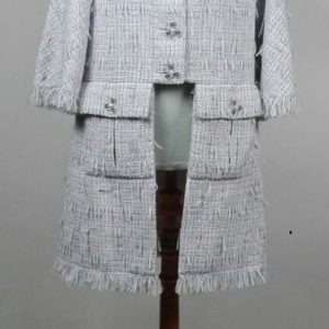 CHANEL, PARIS. Designer : Karl Lagerfeld. Manteau redingote à manches 3/4 et encolure arrondie en tweed à effet de franges dans les tons parme, rose et bleu, deux grandes poches à rabat devant, fermant sur la partie haute par des boutons en plastique transparent siglés. La doublure en soie siglée. Taille notée : 44.