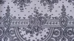 Pièce de dentelle de Chantilly en soie noire réalisée aux fuseaux et jamais montée, à décor de bouquets et guirlandes fleuries sur un fond présentant un semis de pois. XIXe. Dimensions : 930 x 33,5 cm. Provenance : famille PIC-PARIS à Pocé-sur-Cisse.